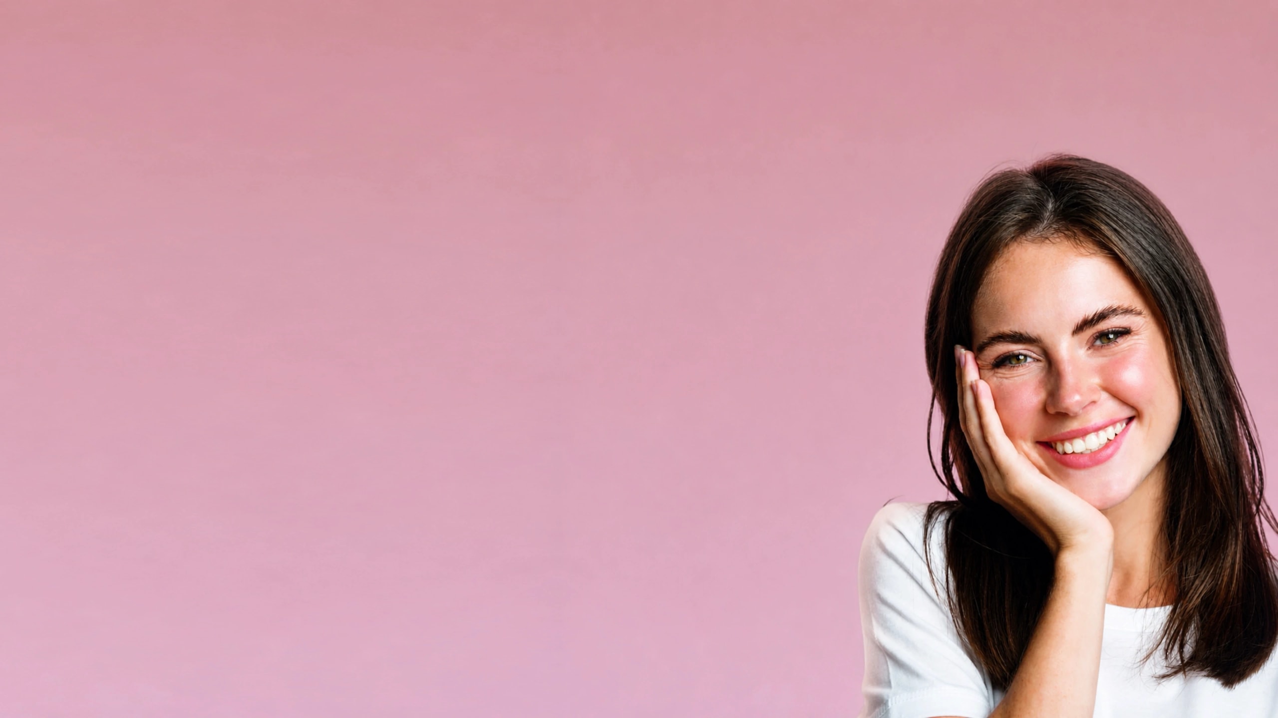 Mujer sonriendo con la mano en la mejilla, sobre fondo rosa — Éclat